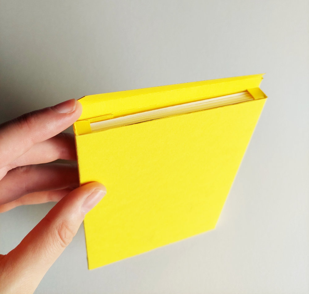 The yellow box of the Portfolio 'bar'. A hand opens it and you can see the top of a series of cards in it.