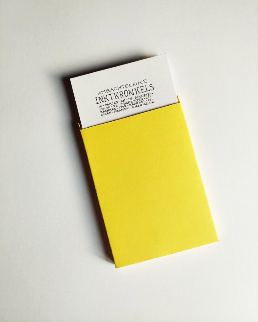 The yellow box of the Portfolio 'bar'. It is opened and you can see a series of cards sticking out. On the front card you can see the same text as on the packaging of the 'bar'.